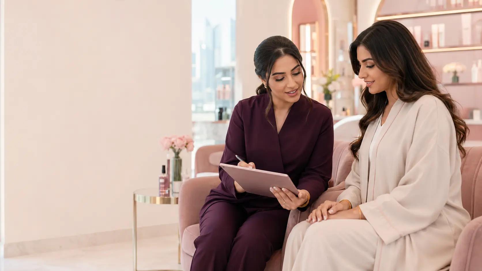 خبيرة تجميل من سابيوتي تراجع نموذج استشارة الخدمة مع عميلة في صالون سيدات أنيق بدبي